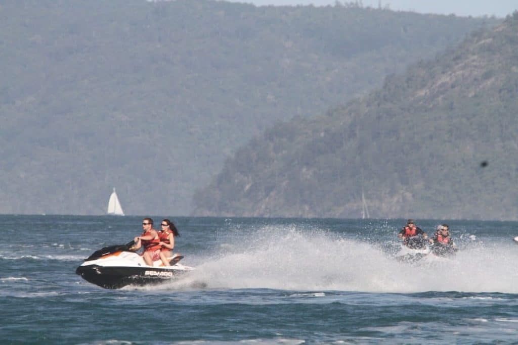 Ejemplo de conducción de un Sea-Doo con un pasajero a alta velocidad y otros que lo siguen